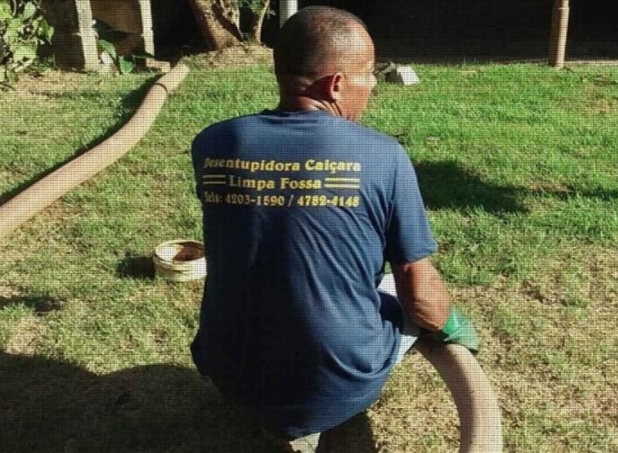 Profissional uniformizado da Desentupidora Caiçara pronto para o serviço de desentupimento.